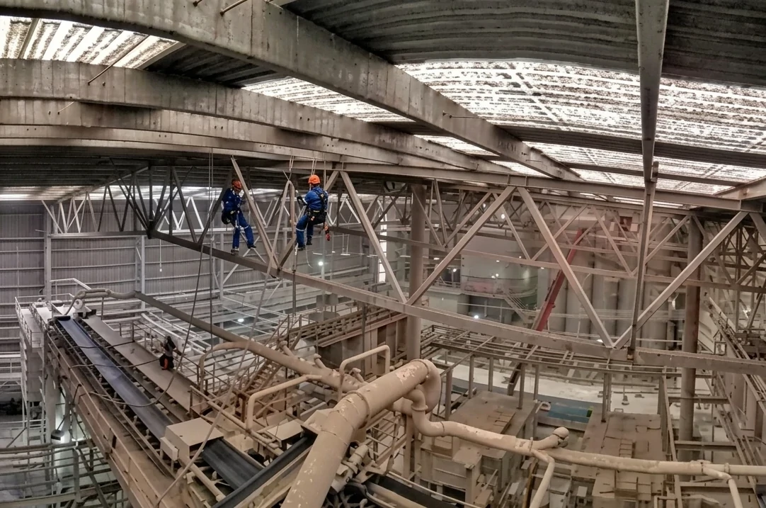 Trabajadores realizando mantenimiento de nave industrial en altura